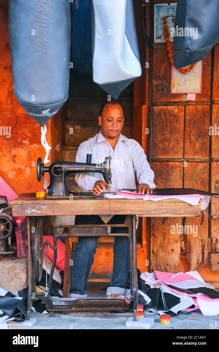 Local man making motorbike seat covers at Johari Bazaar street in Jaipur, Rajasthan, India. Jaipur is the capital and the largest city of Rajasthan. Stock Photo