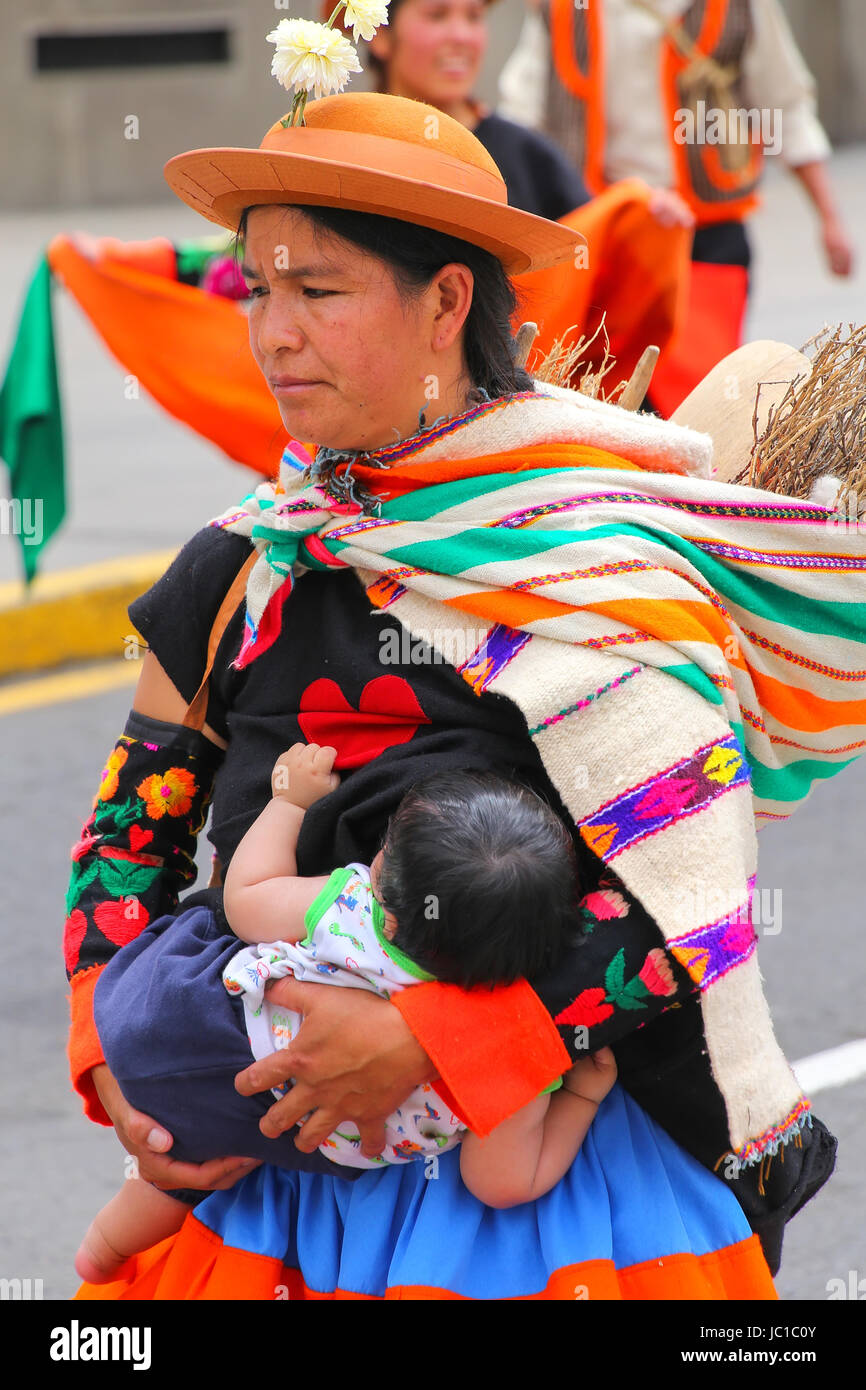 Local woman with a baby walking during Festival of the Virgin de la Candelaria in Lima, Peru. The core of the festival is dancing and music performed  Stock Photo