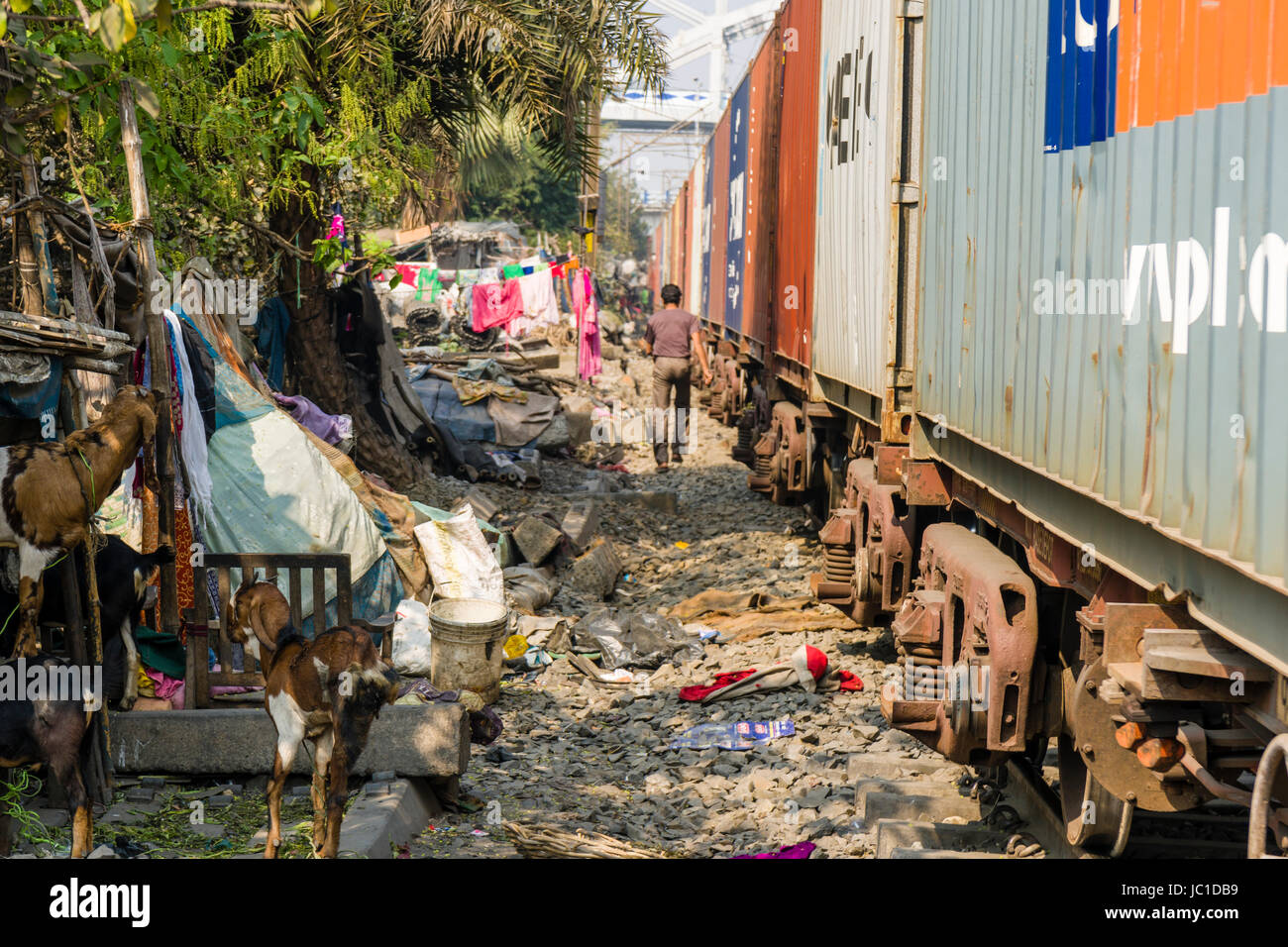 The dwellings in Park Circus slum area are located right next to the railroad tracks, a train is passing through Stock Photo