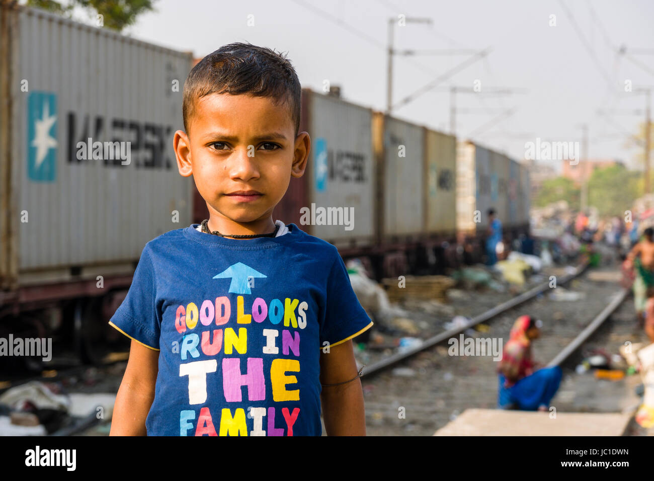 Portrait of a child boy in Park Circus slum area, a train is passing through Stock Photo