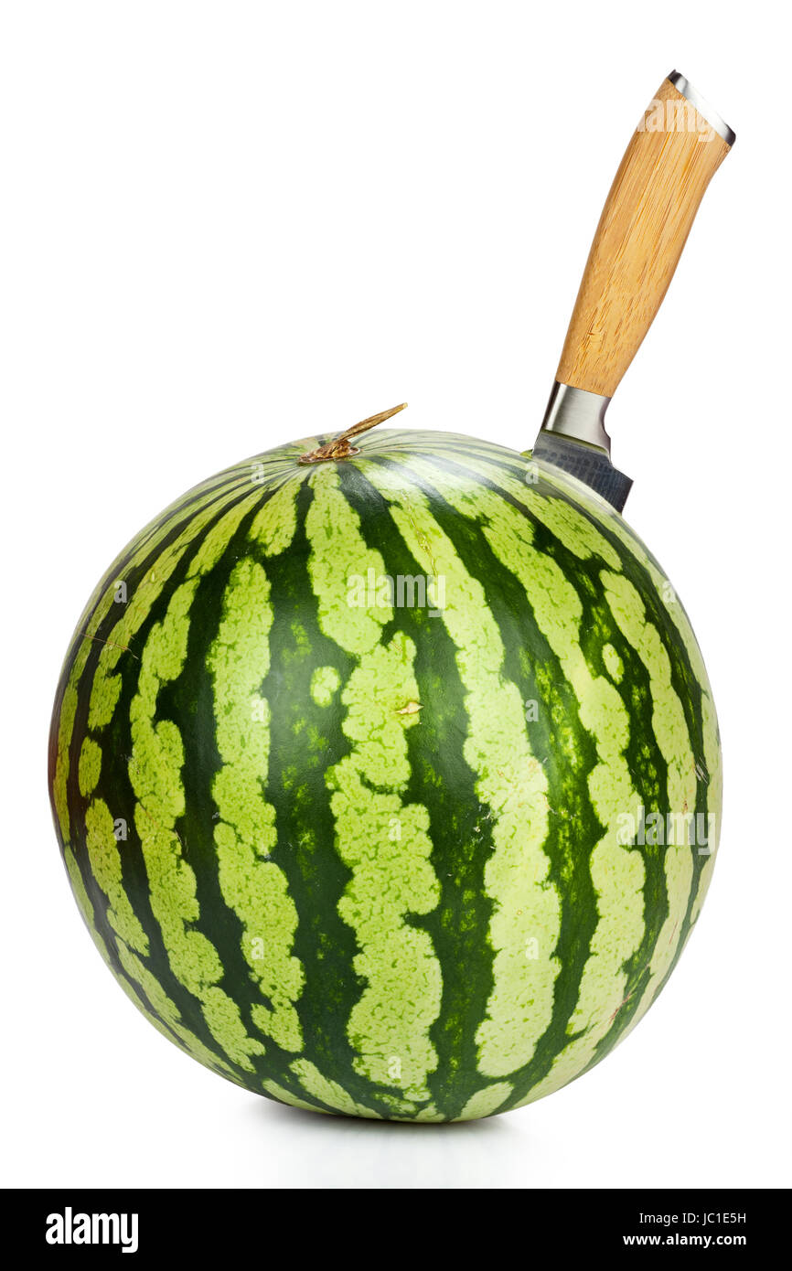 Messer steckt in Wassermelone isoliert vor weißem Hintergrund Stock Photo