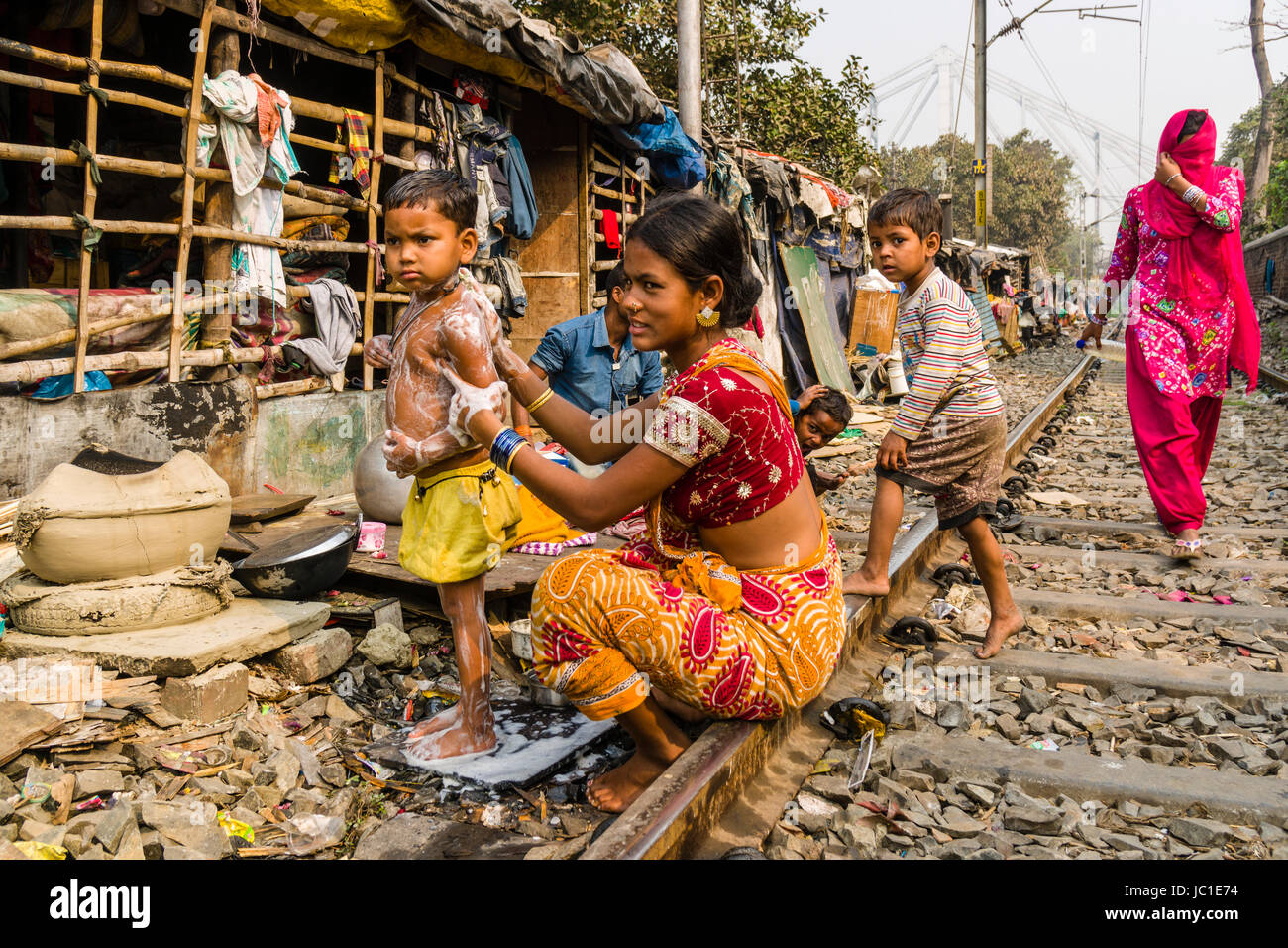The dwellings and huts in China Bazar slum area are located right next to  the railroad tracks, people are sitting on the tracks Stock Photo - Alamy