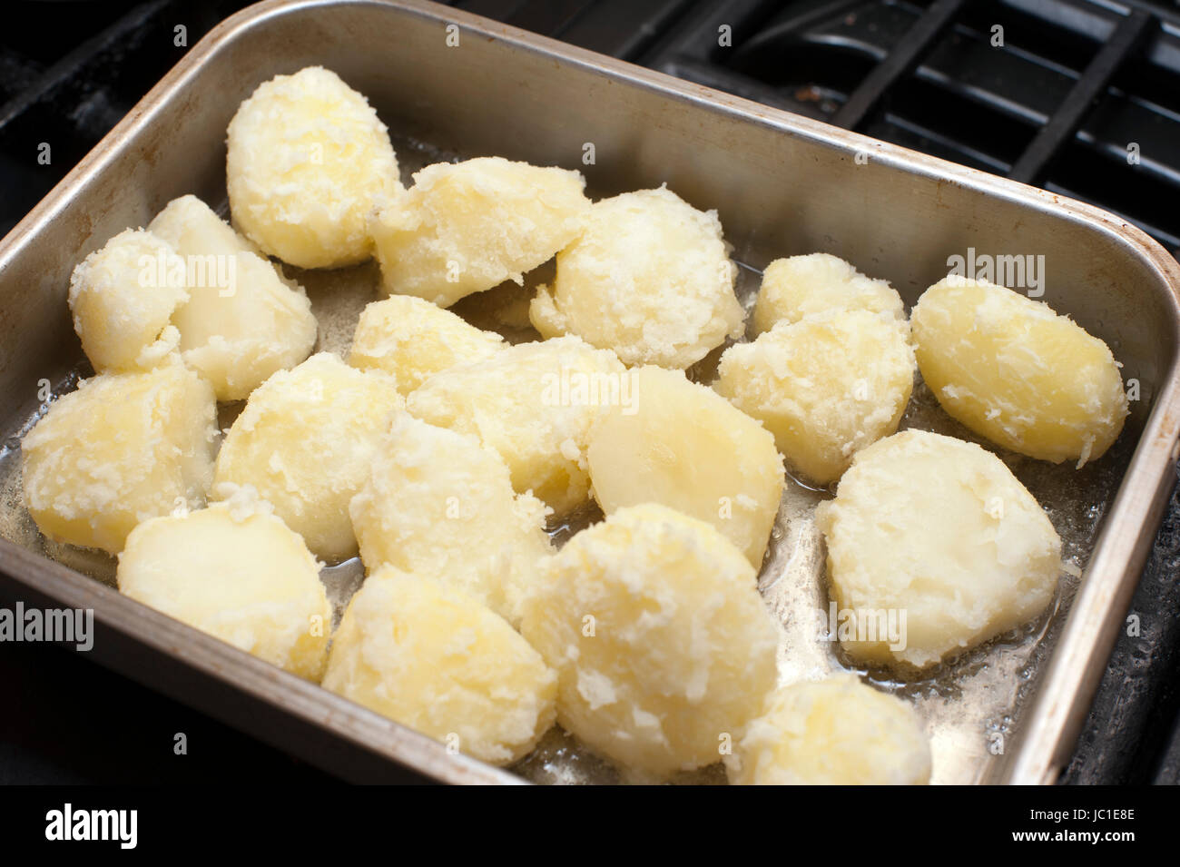 Preparing roast potatoes by par boiling them and placing them in an
