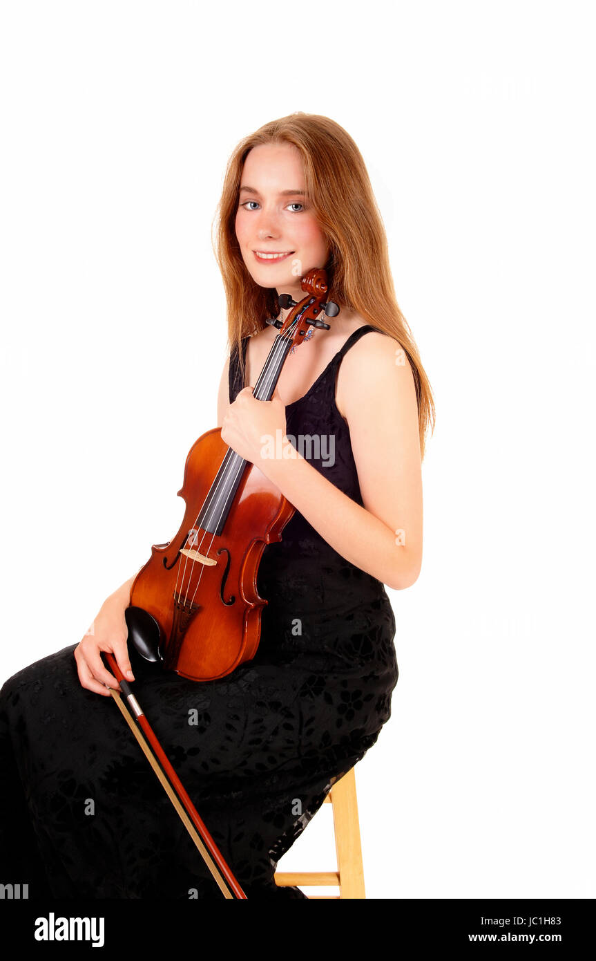 A pretty woman in a black dress sitting and holding her violin, smiling ...