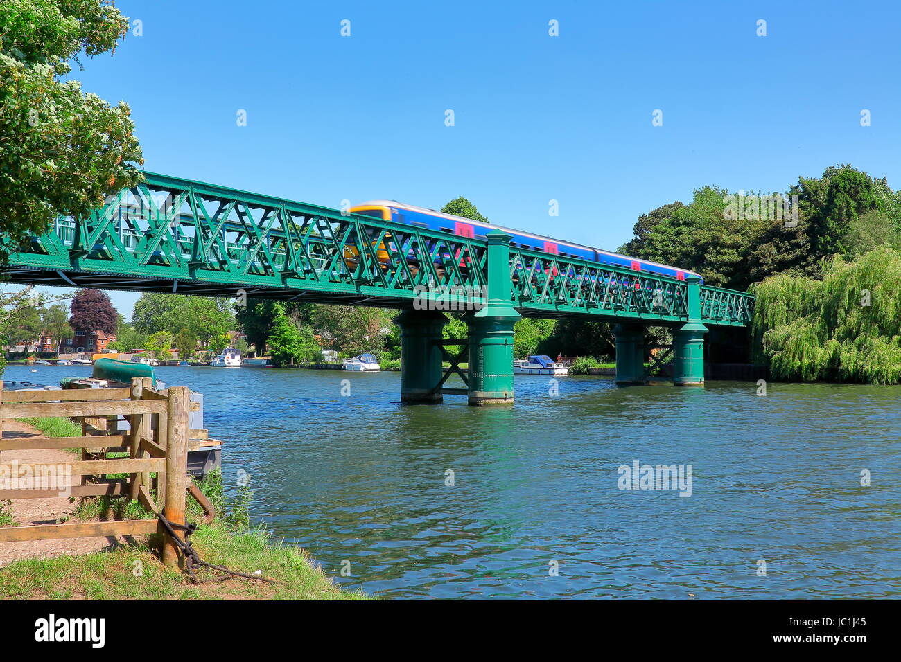 Green painted steel bridge over the Thames at Bourne end with a train