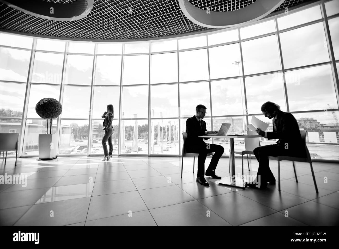 Two businessmen and businesswoman working in office Stock Photo - Alamy