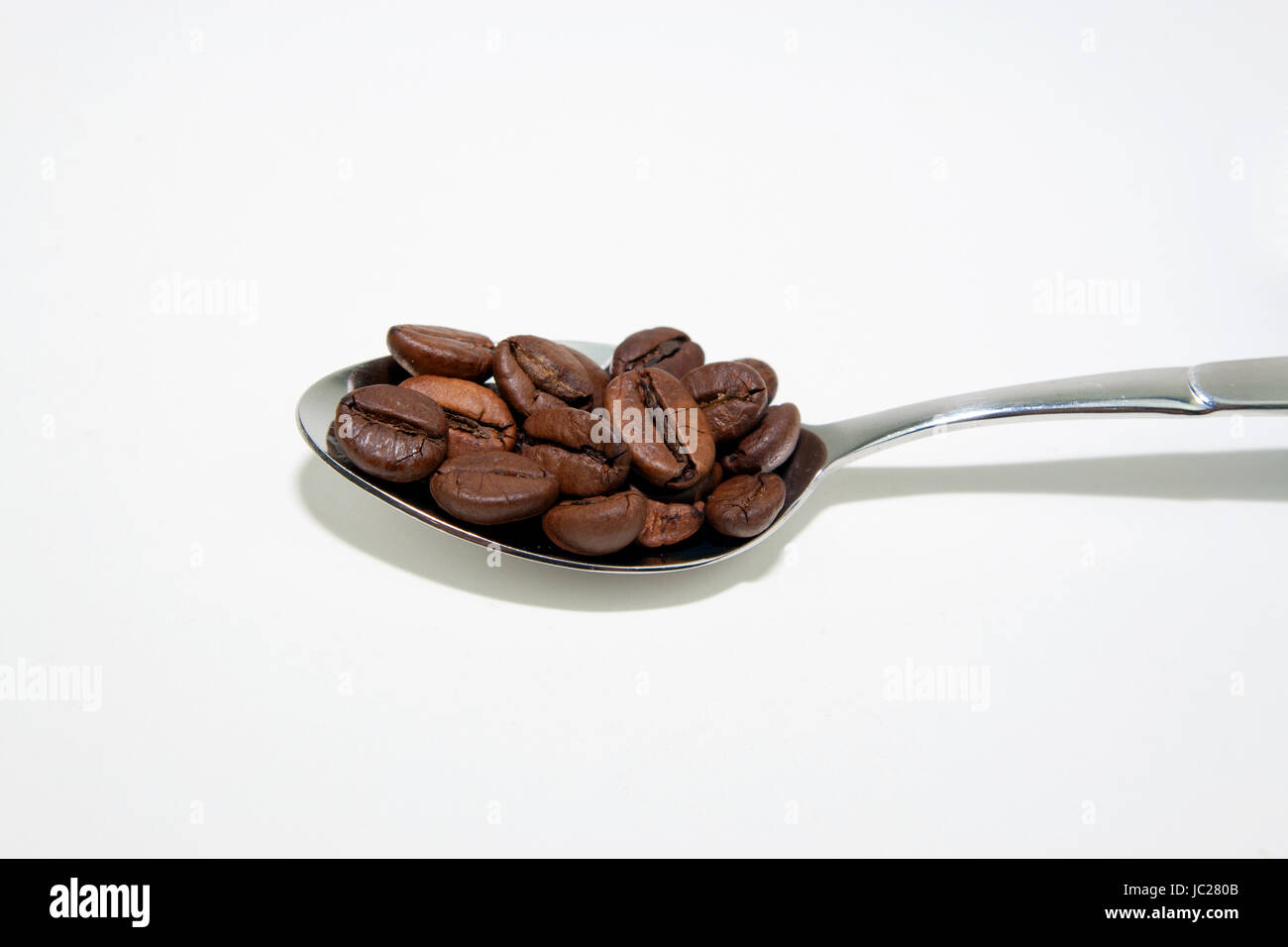 Teeloeffel mit Kaffeebohnen Stock Photo