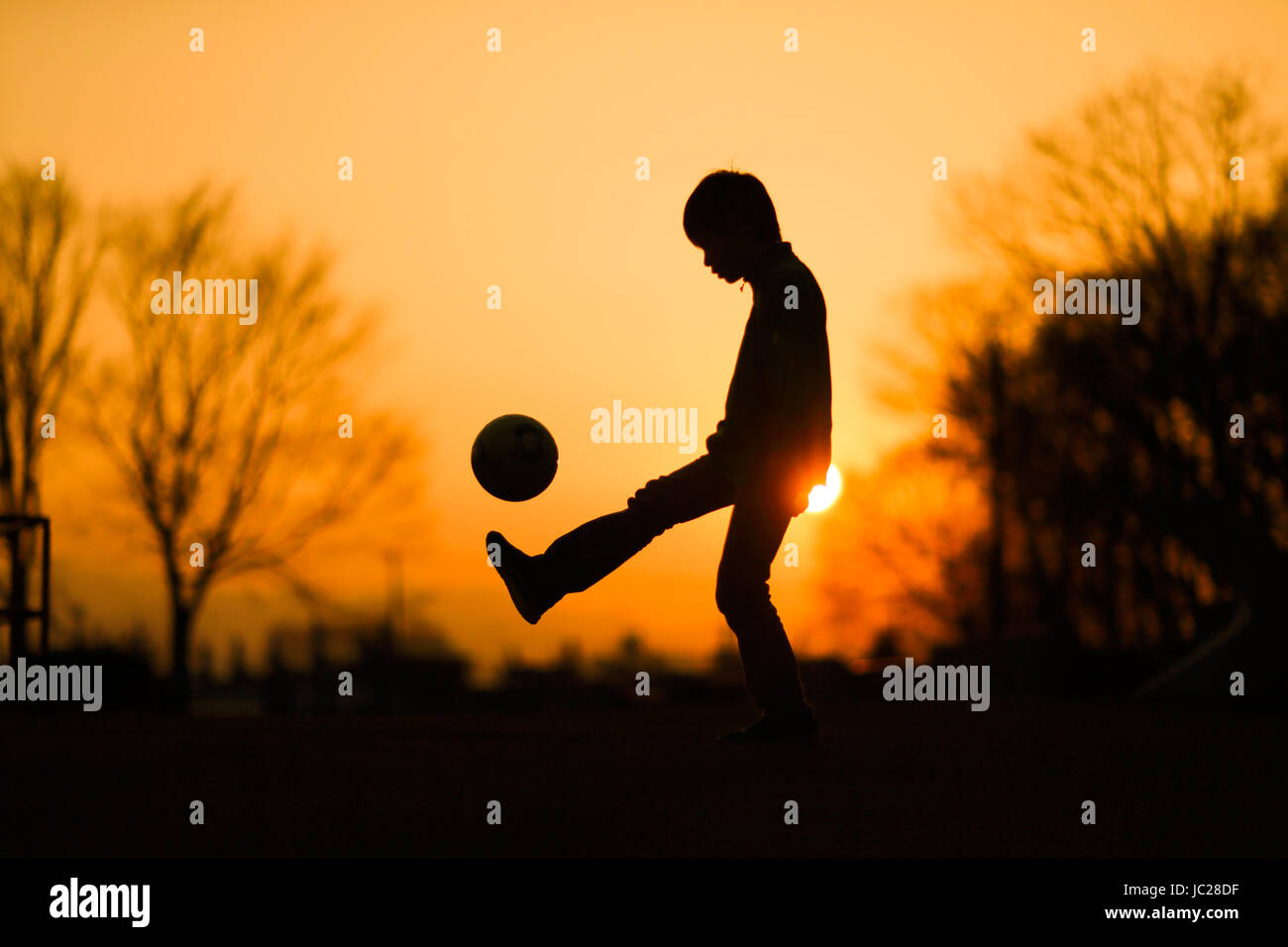 Boy Lifting Ball Stock Photo - Alamy