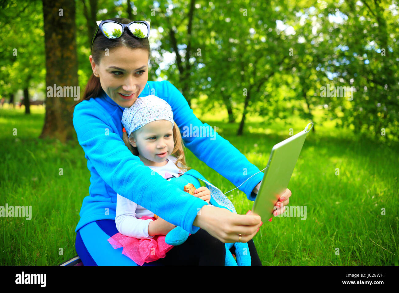 Family rest scene. Mom and kid do selfie on green nature background ...