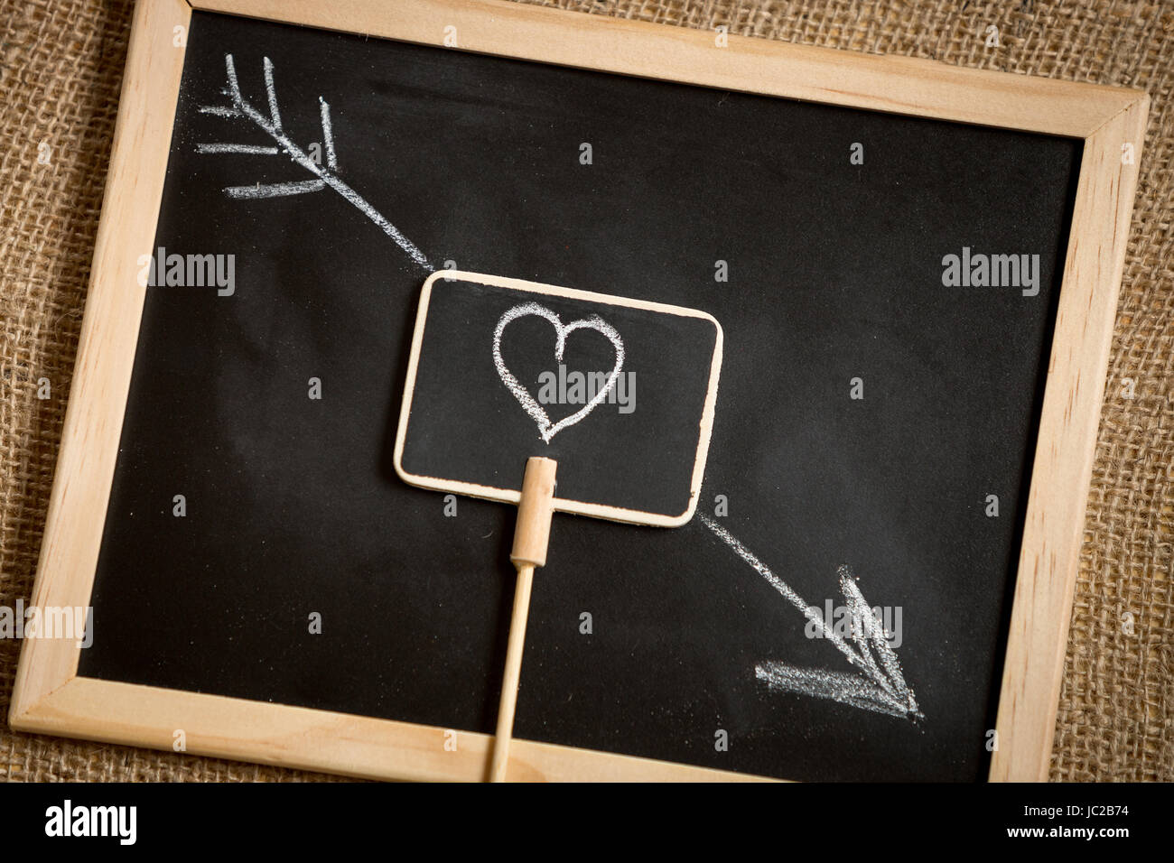 Closeup photo of arrow going through heart drawn on blackboard Stock ...