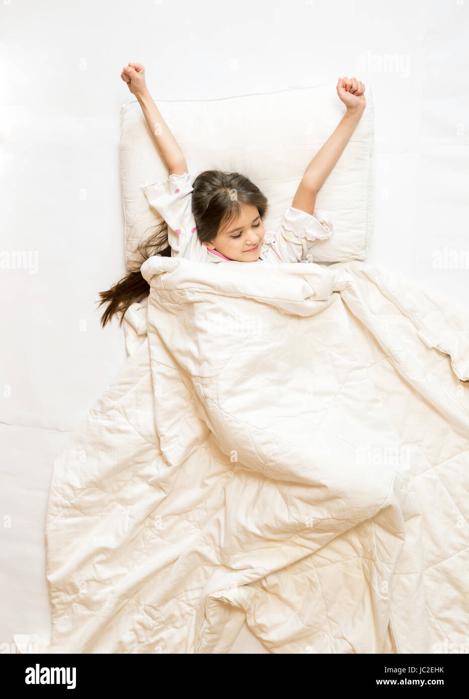 Isolated photo of cute girl being awake and stretching in bed Stock ...