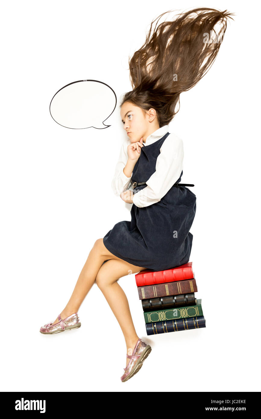 Isolated photo of thoughtful schoolgirl sitting on pile of books Stock ...
