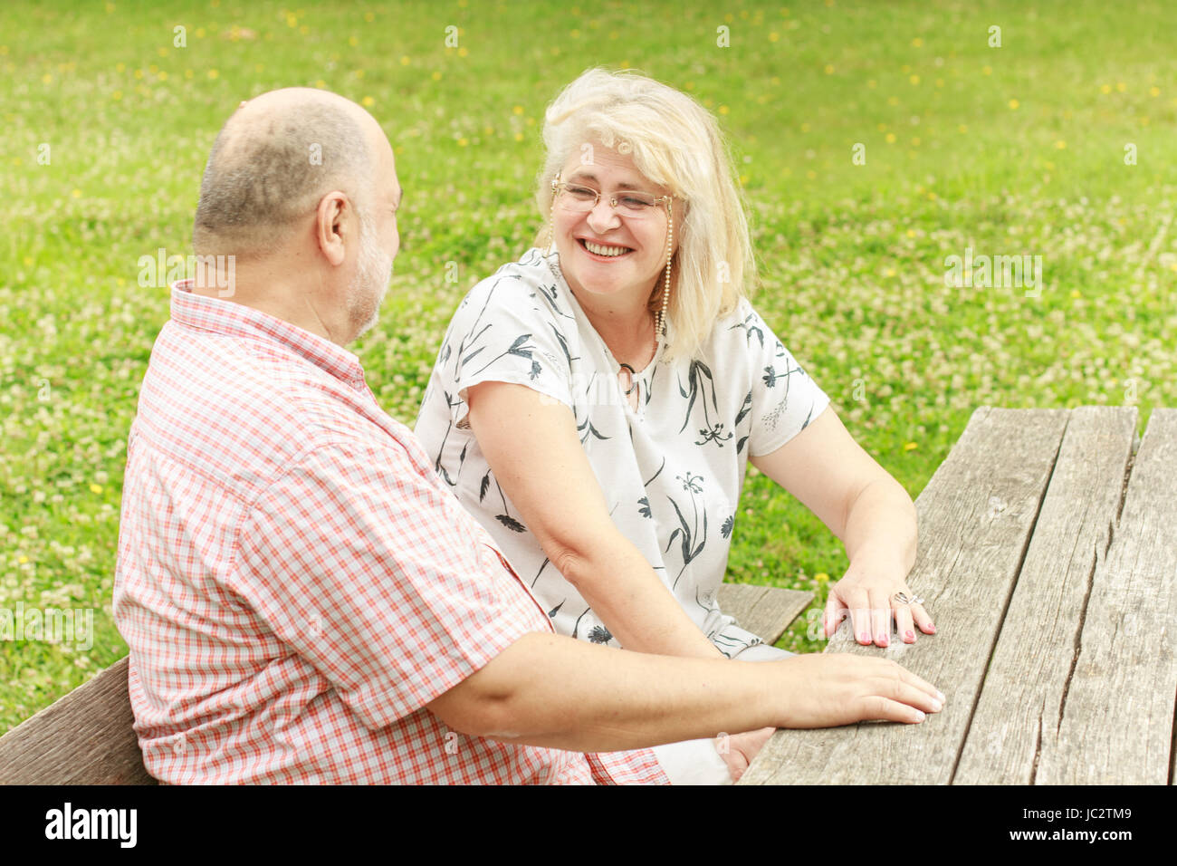 Elderly couple relaxing on the bench in park Stock Photo - Alamy