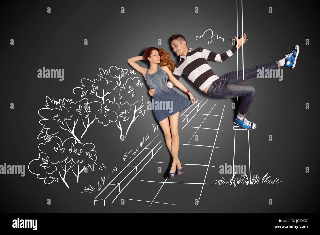 Happy valentines love story concept of a romantic couple against chalk  drawings background. Male pole dancing on a lamppost while walking with  girlfriend Stock Photo - Alamy