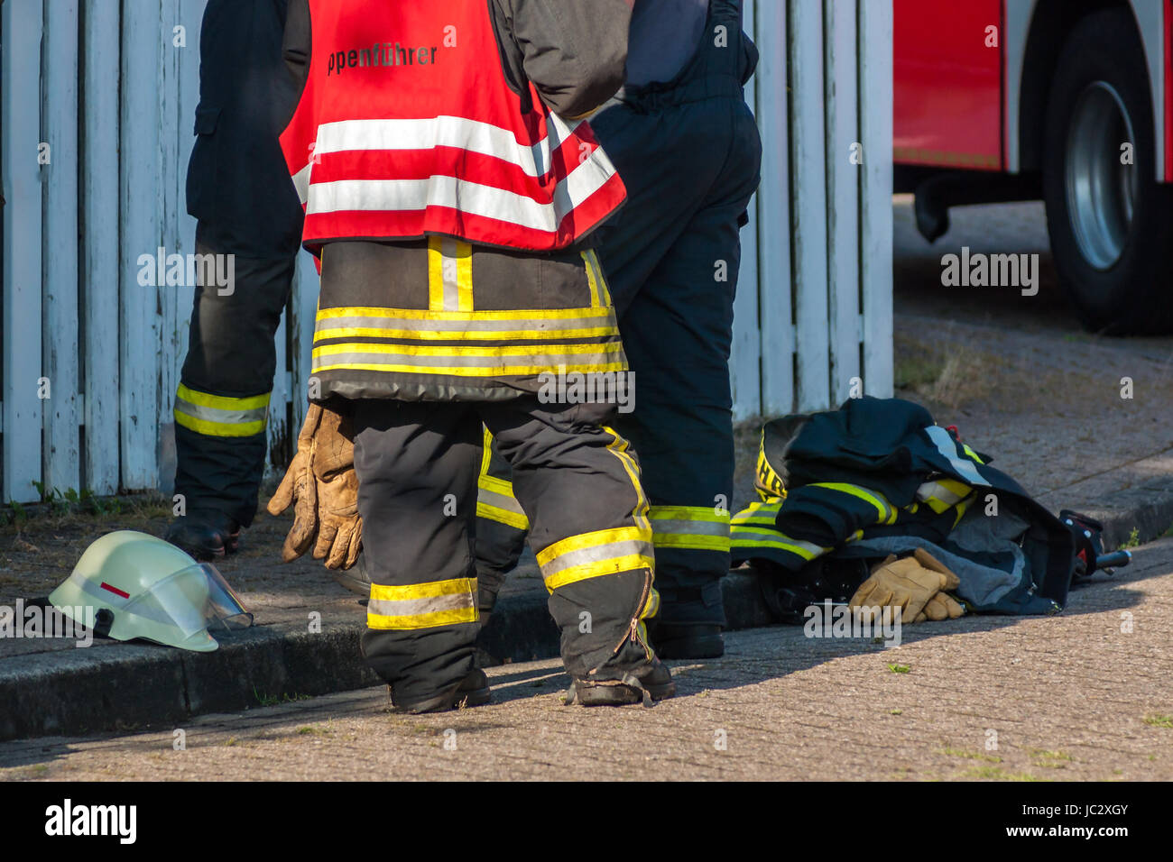 Beine von 3 Feuerwehrmänners nach einem Einsatz Stock Photo