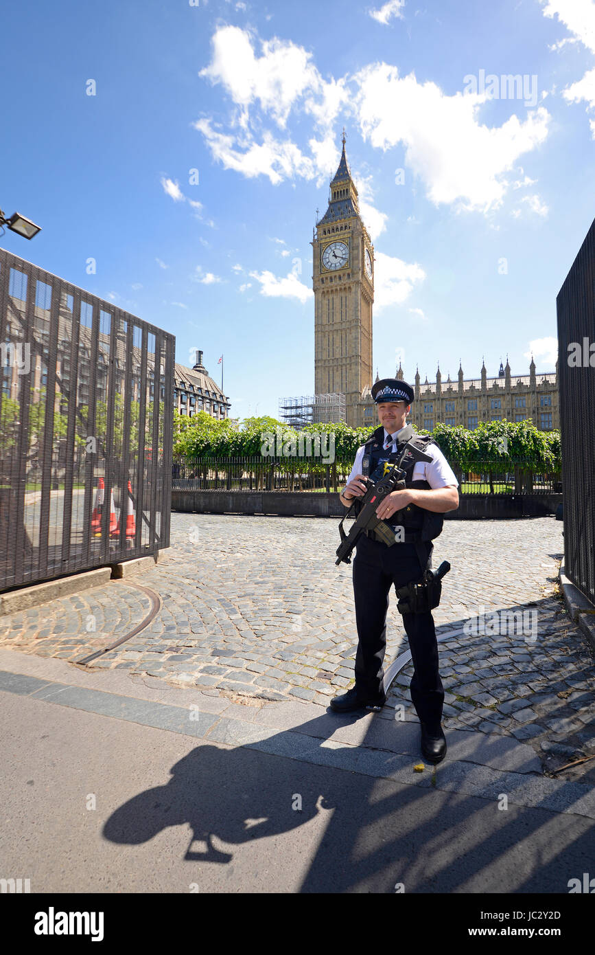 Armed British policeman guarding the gate to the Houses of Parliament, Palace of Westminster. London, UK. Open gate. Gates open Stock Photo