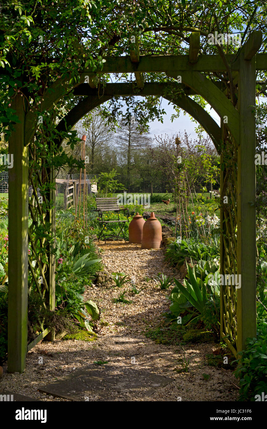 wooden arbour arch leading into english vegetable garden Stock Photo