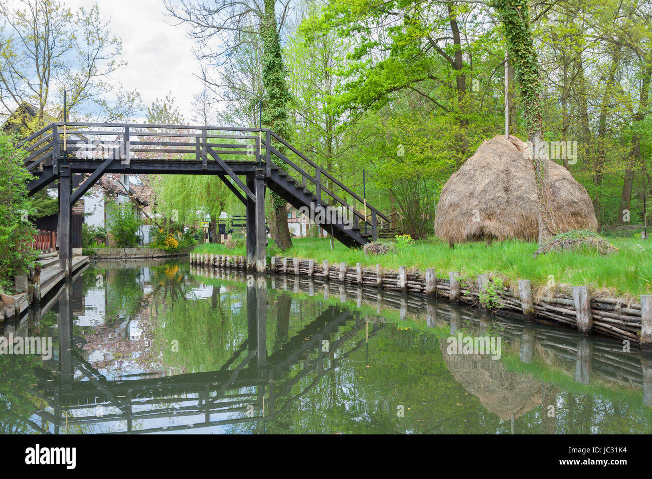 Kleine Holzbrücke über einen Kanal und ein für die Gegend typischen Heuhaufen Stock Photo