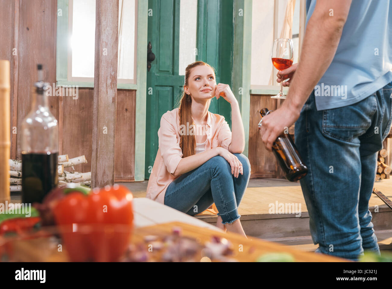 attractive woman and man resting with beer and wine on porch Stock Photo