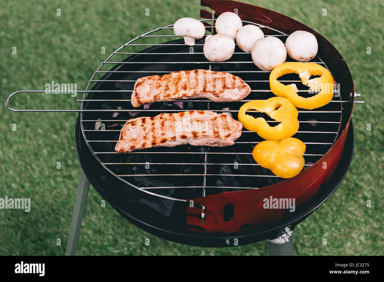 meat, yellow peppers and mushrooms roasting on barbecue grill Stock
