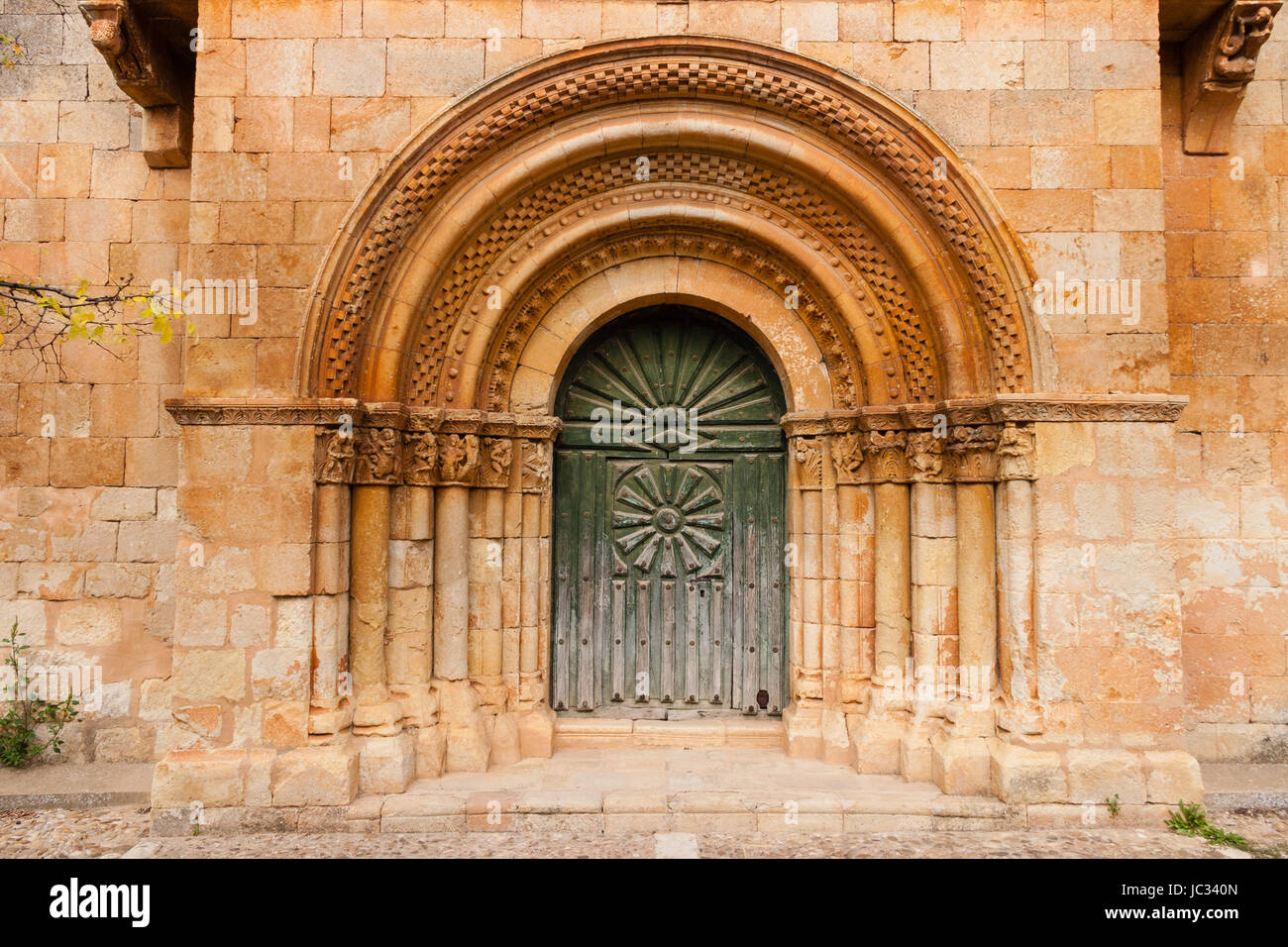 Romanesque portal with fine archivolts and beautiful door of the church in a small village called Moarves de Ojeda in the povince of Palencia  Spain Stock Photo