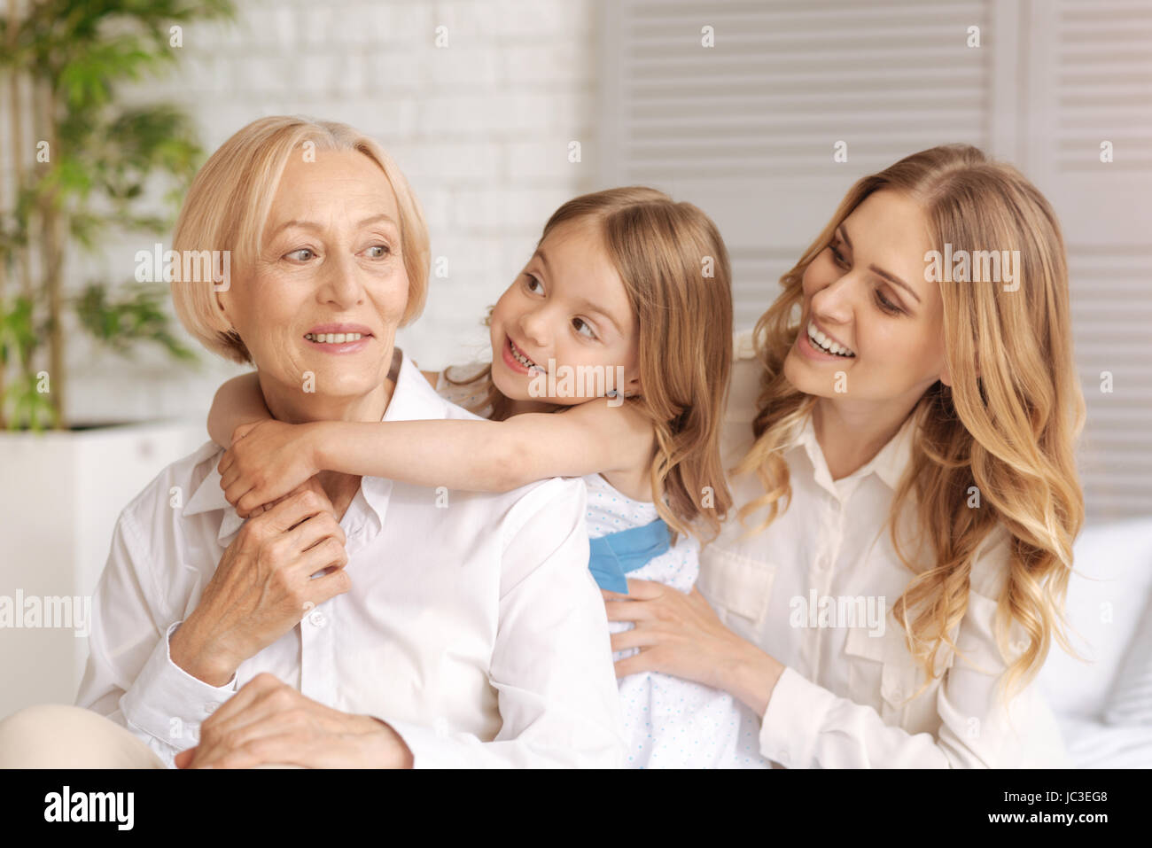 Cheerful amused mother and child looking at the grandmother Stock Photo