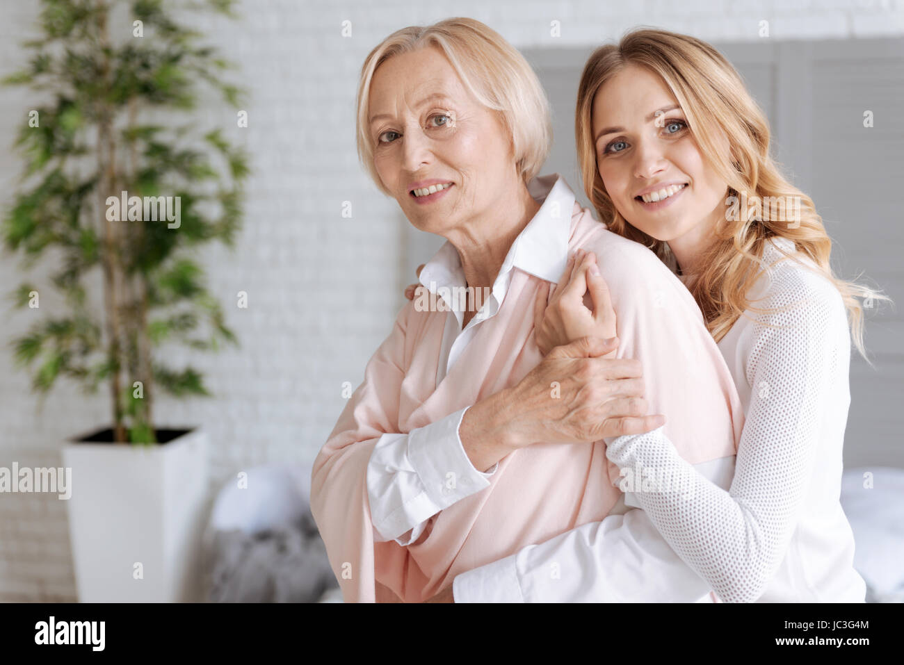 Mother covering her daughters hand embracing her Stock Photo