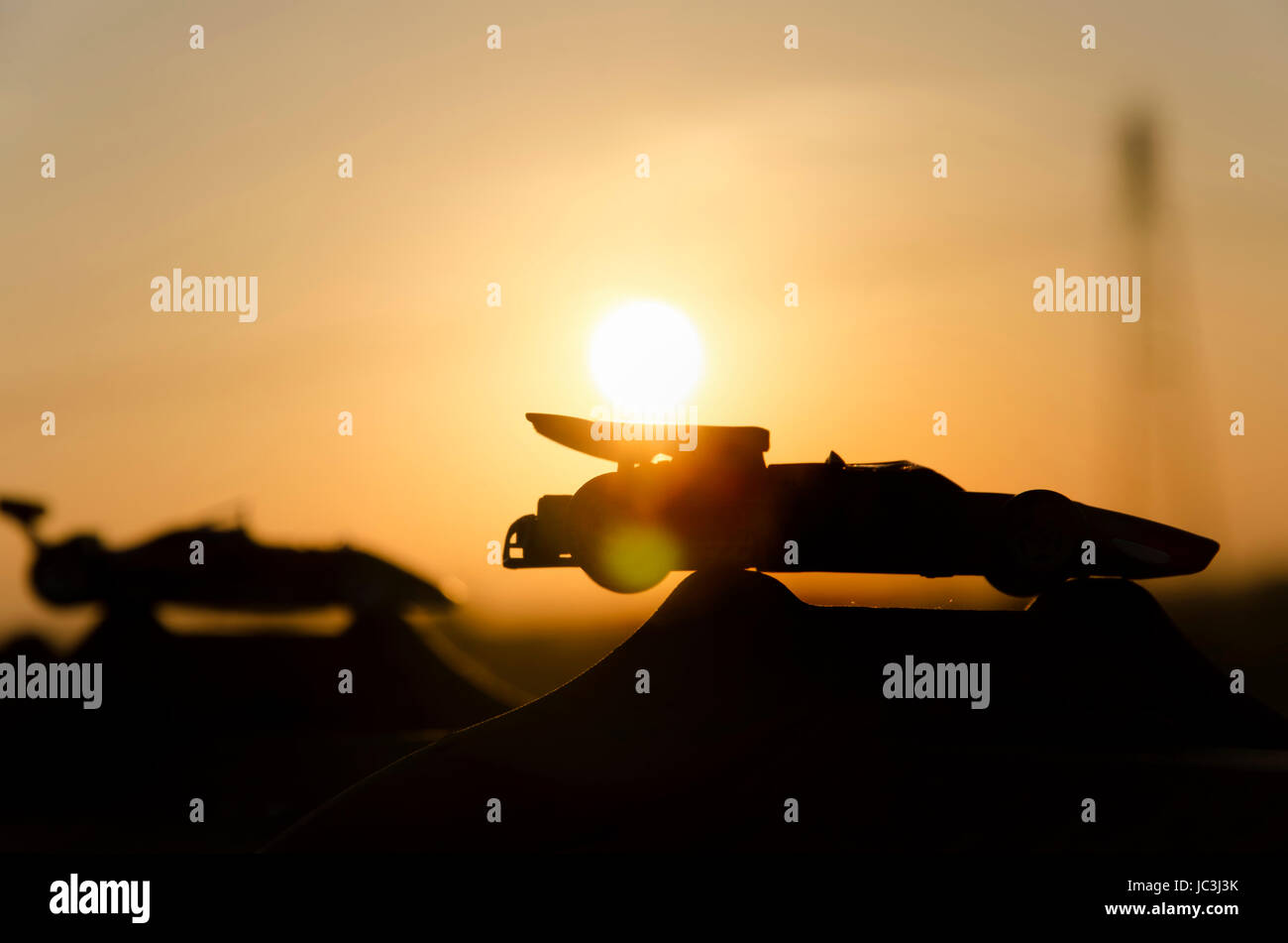 View of two historic single-seaters with sunset in background Stock Photo