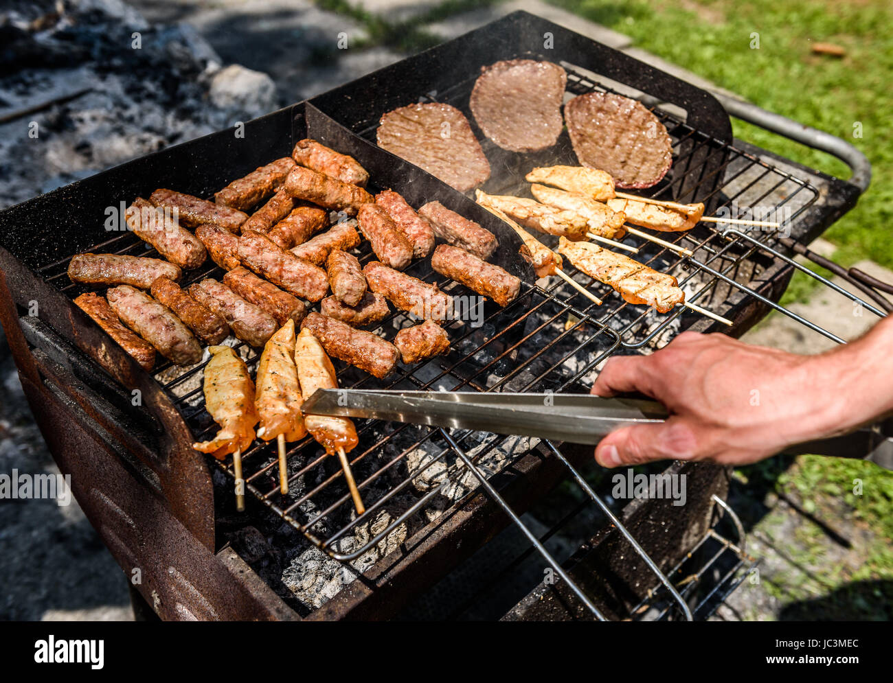 Delicious meat on barbecue grill with coal outdoors picnic. Grilling food  on backyard or a terrace Old small cheap BBQ grill at home Stock Photo -  Alamy