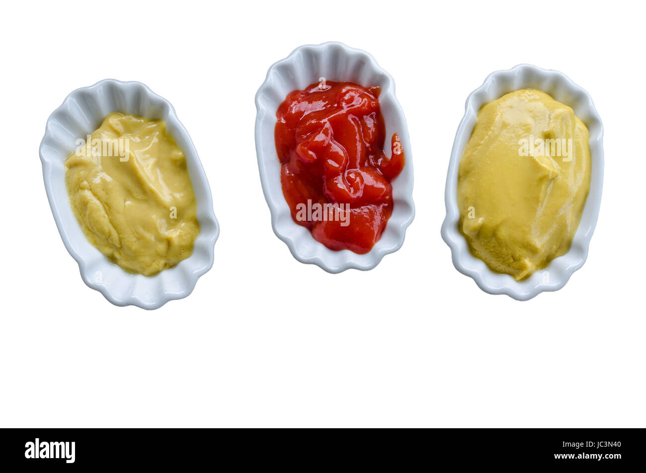 Nahaufnahme von Ketchup und Senf auf drei kleinen weißem Tellern. Stock Photo