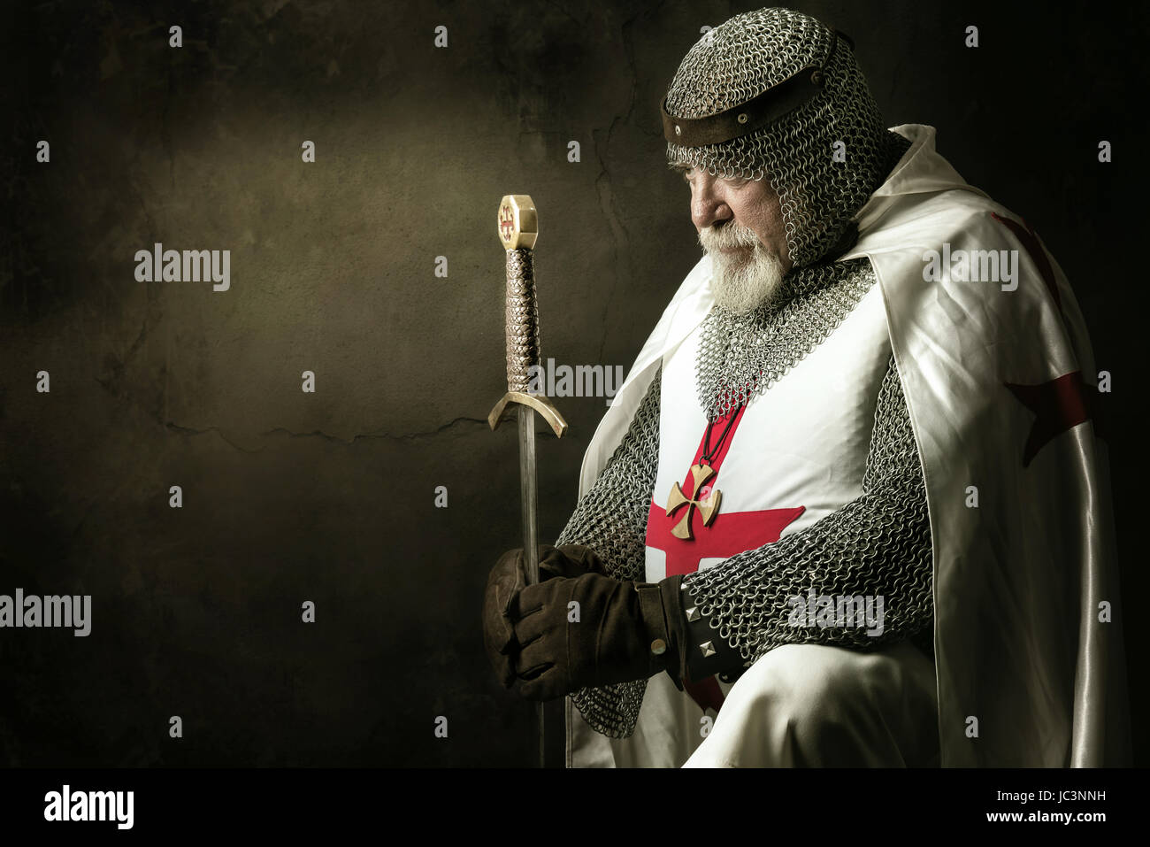 Templar knight praying in a dark background Stock Photo