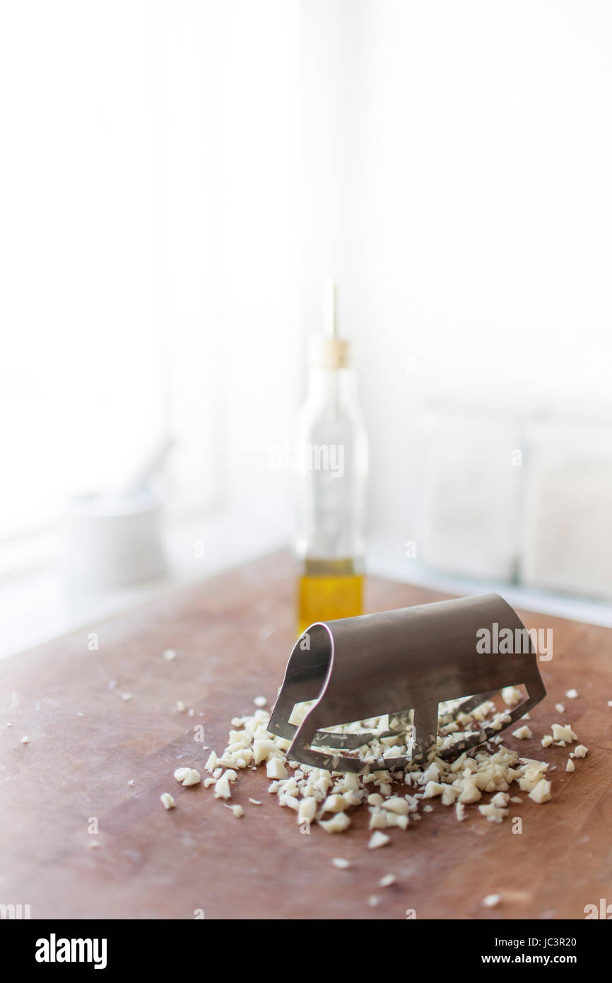Garlic being chopped with a mincing knife Stock Photo Alamy