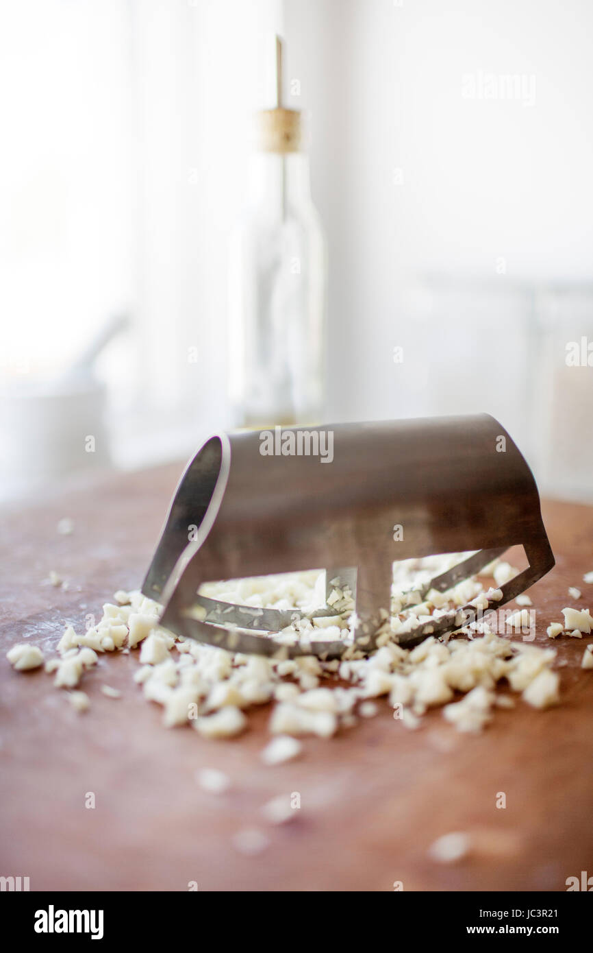 Garlic being chopped with a mincing knife Stock Photo Alamy