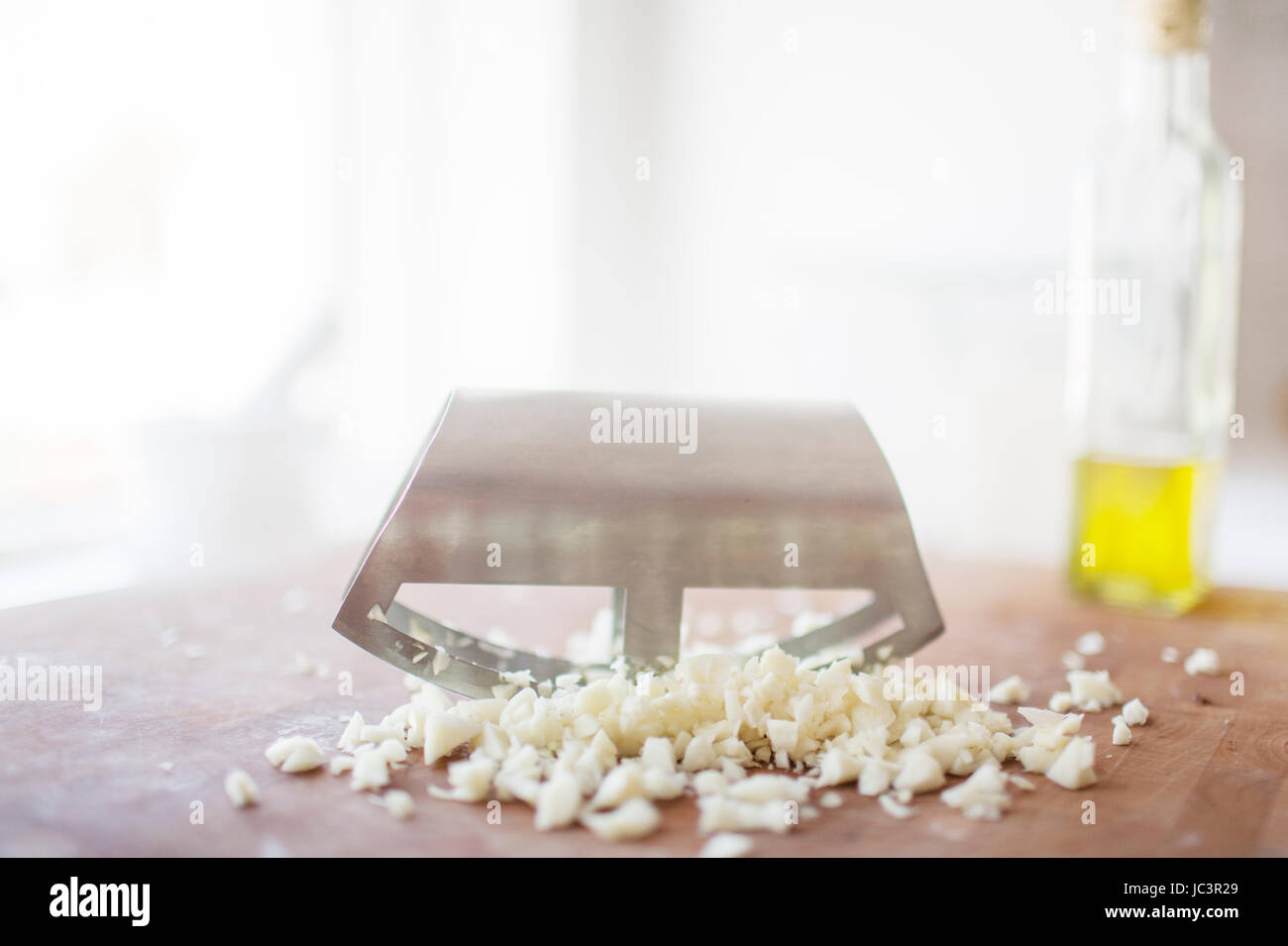 Garlic being chopped with a mincing knife Stock Photo Alamy