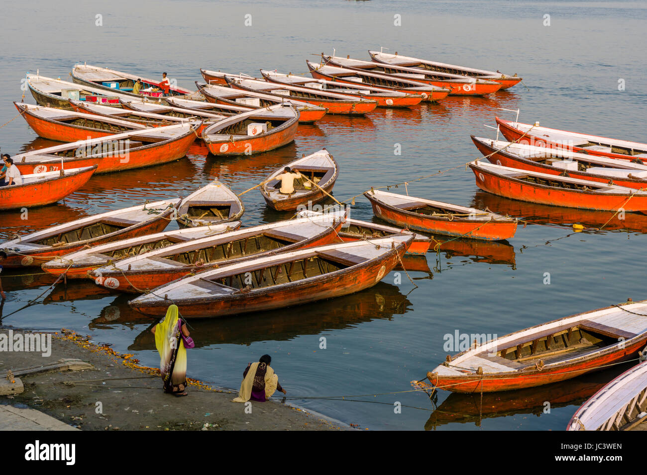 Many colorful rowing boats are tight up at Dashashwamedh Ghat, Main Ghat, in the suburb Godowlia at the holy river Ganges Stock Photo