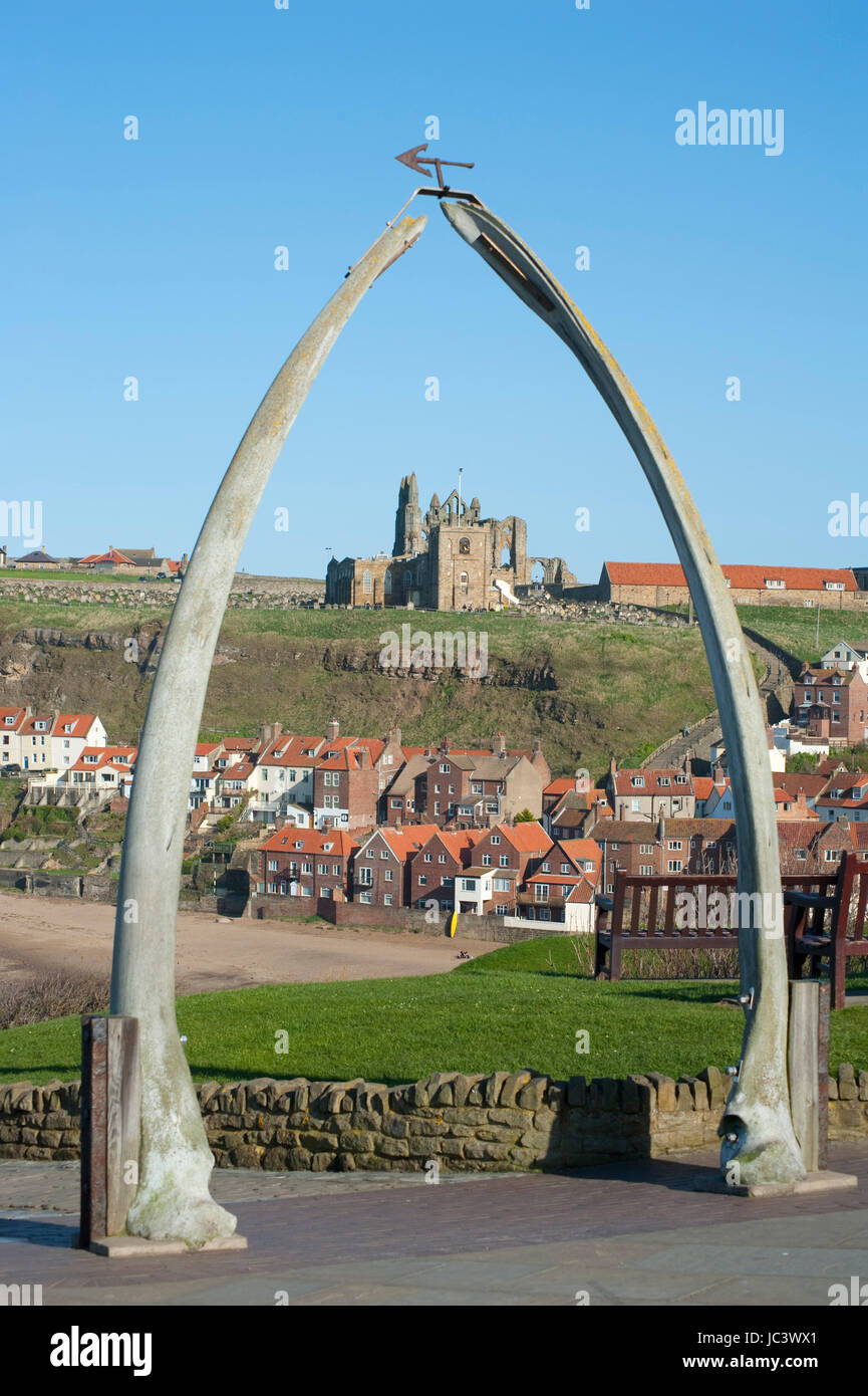Whalebone arch in Whitby, North Yorkshire, constructed from two jaw bones to commemorate whaling in the region framing the ruins of Whitby Abbey on Tate Hill Stock Photo
