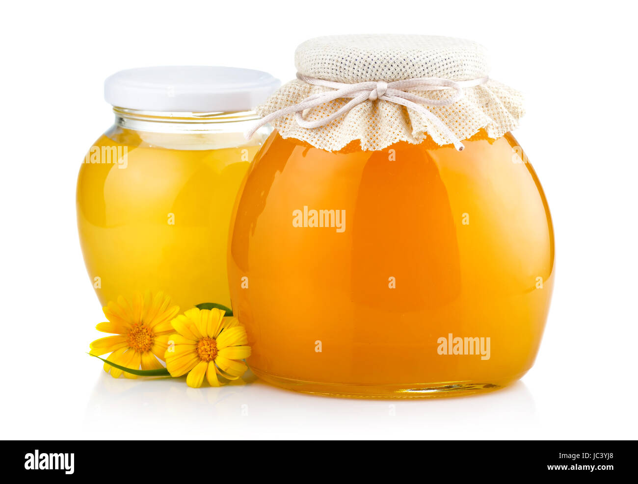 Sweet honey in glass jars with flowers isolated on white background Stock Photo