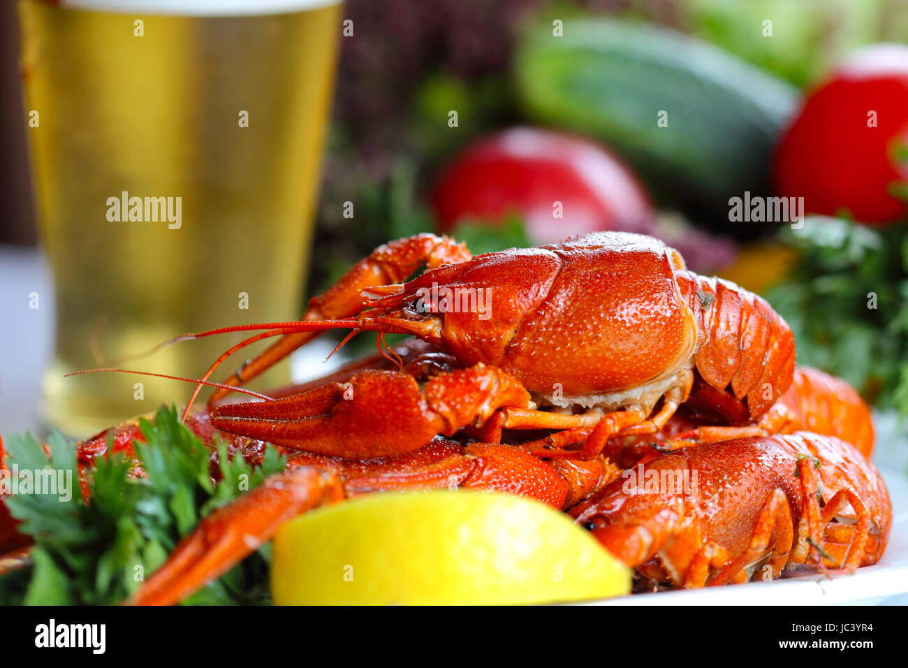 Heap of boiled crafish, glass of beer and garnish (colseup, selective focus) Stock Photo