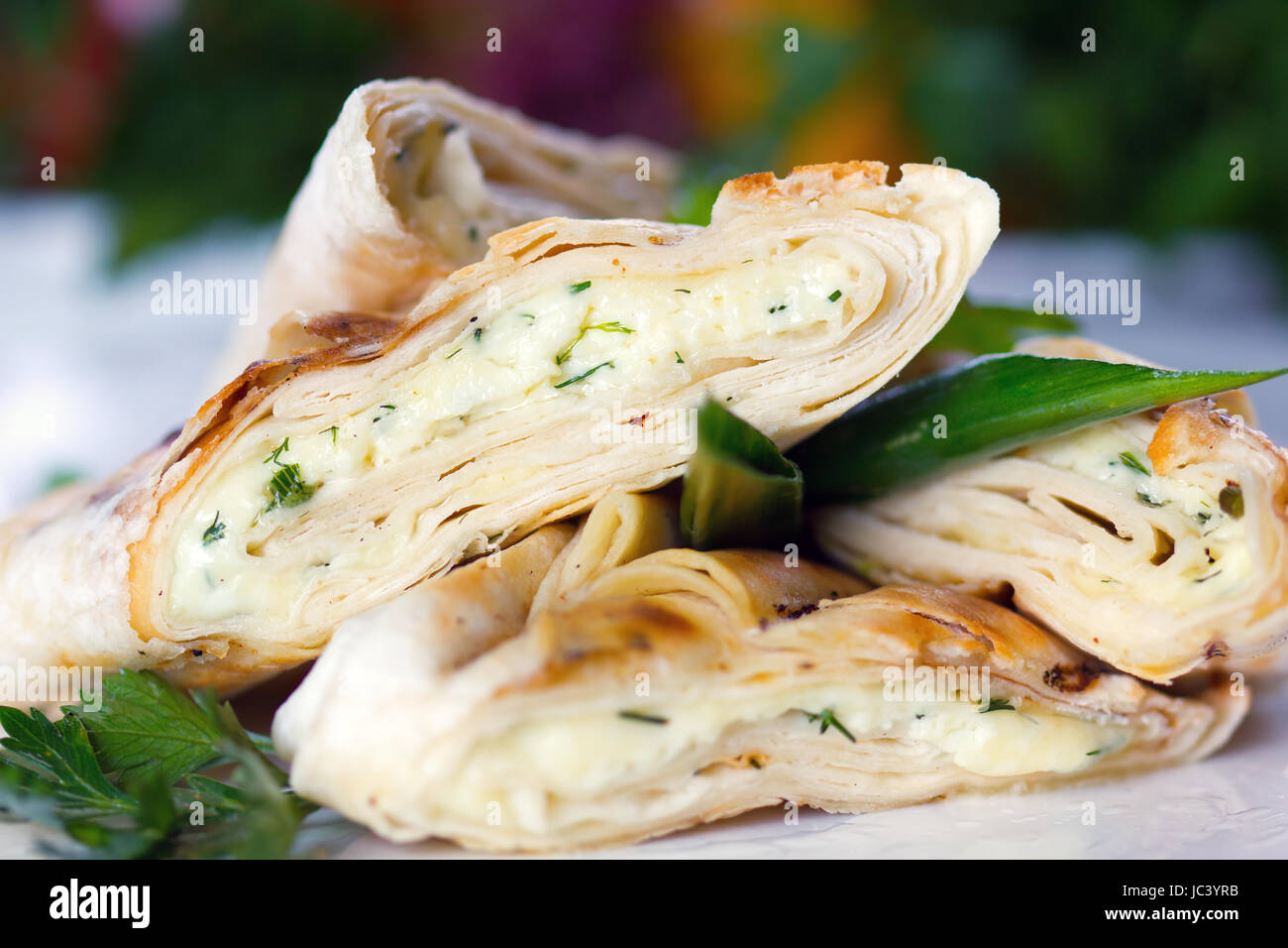 Roasted pancake with sheep cheese and greens (closeup, selective focus) Stock Photo