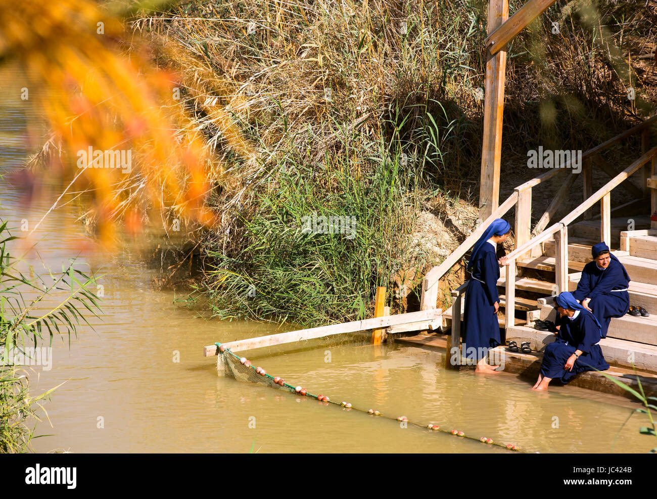 BETHABARA, ISRAEL - OCTOBER- 7, 2016: Pilgrims Catholic nuns on the banks of the Jordan River at the site of Jesus' baptism. Israel Stock Photo