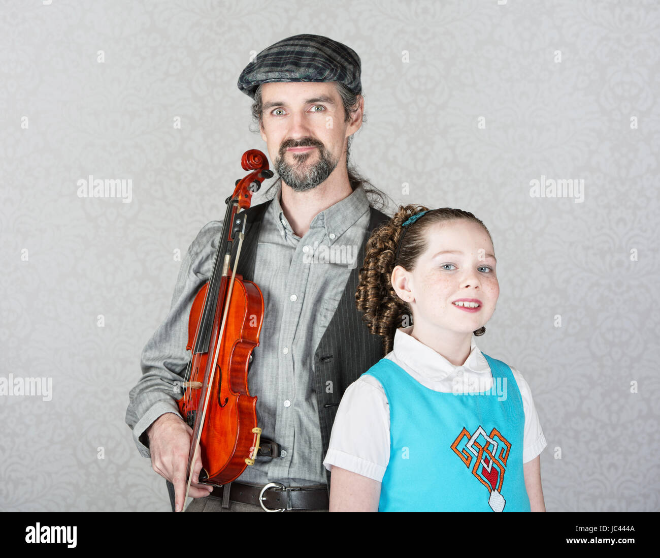 Irish folk music parent holding violin with cute child Stock Photo
