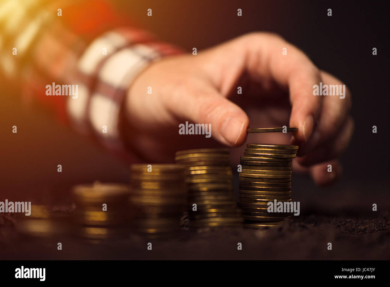 Farmer stacking coins, agricultural income and profit increase Stock Photo