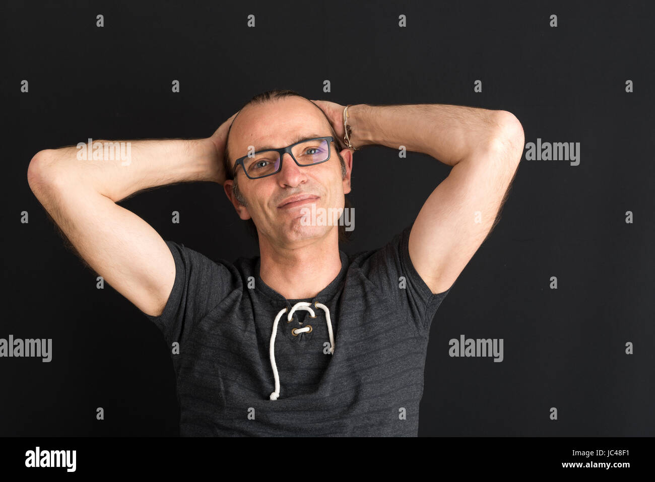 Portrait of a easygoing middleaged european adult - studioshot against dark background Stock Photo