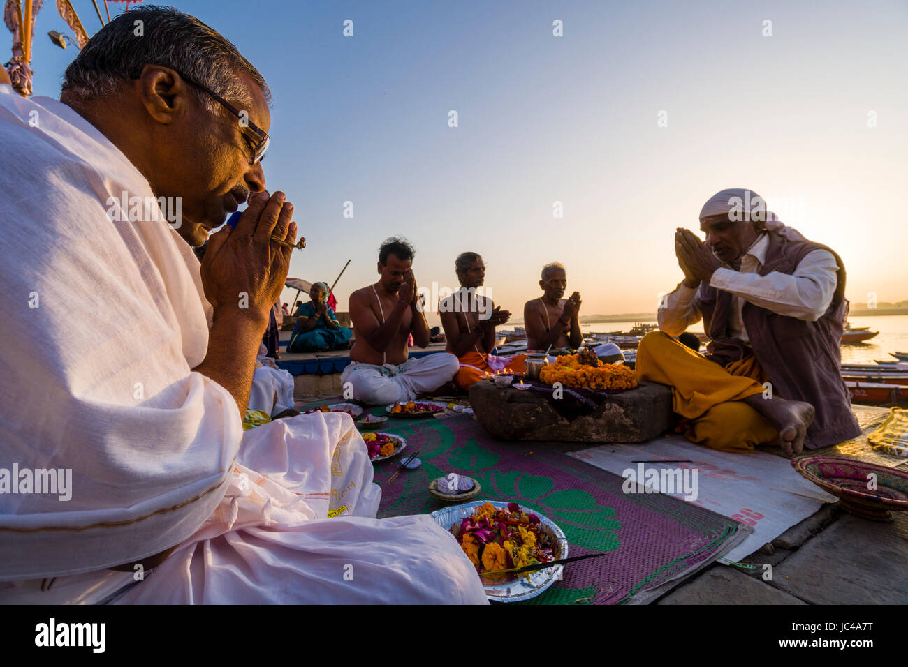 A priest, Brahmin, is working with pilgrims at the holy river Ganges at Dashashwamedh Ghat, Main Ghat, in the suburb Godowlia Stock Photo