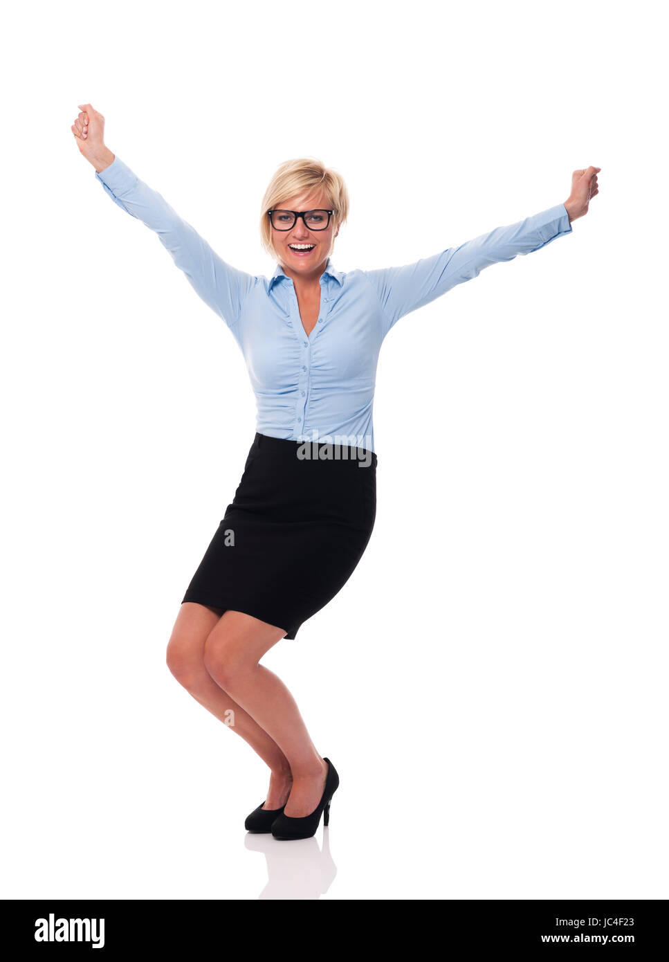 Excited young businesswoman with hands raised Stock Photo