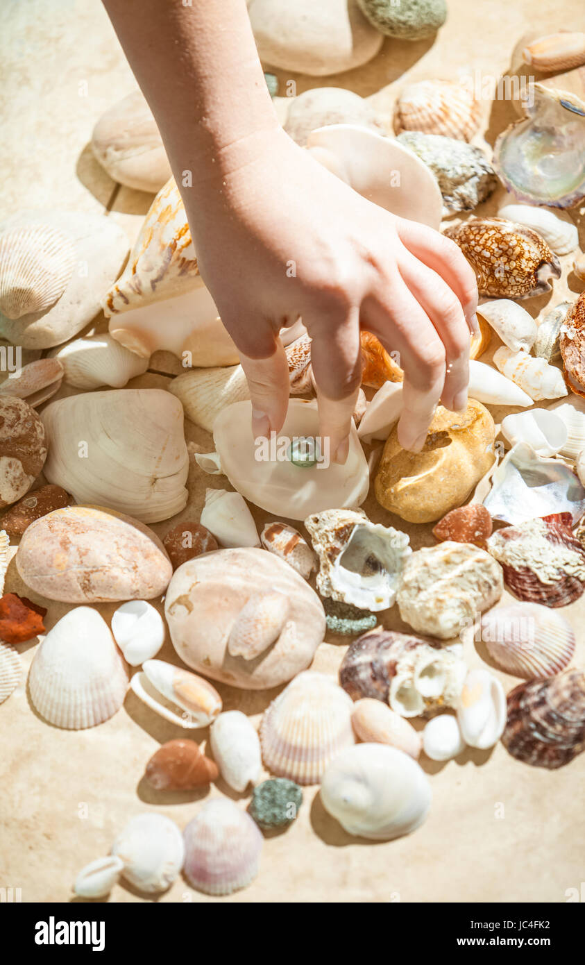 Closeup shot of hand picking black pearl from sea bottom Stock Photo