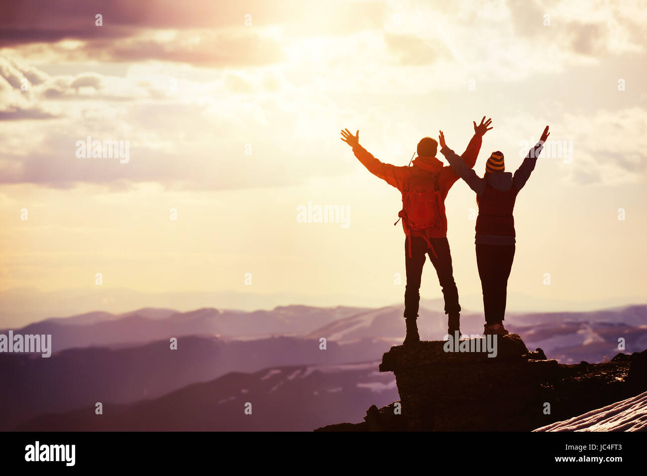Happy couple sunset winners mountain top Stock Photo