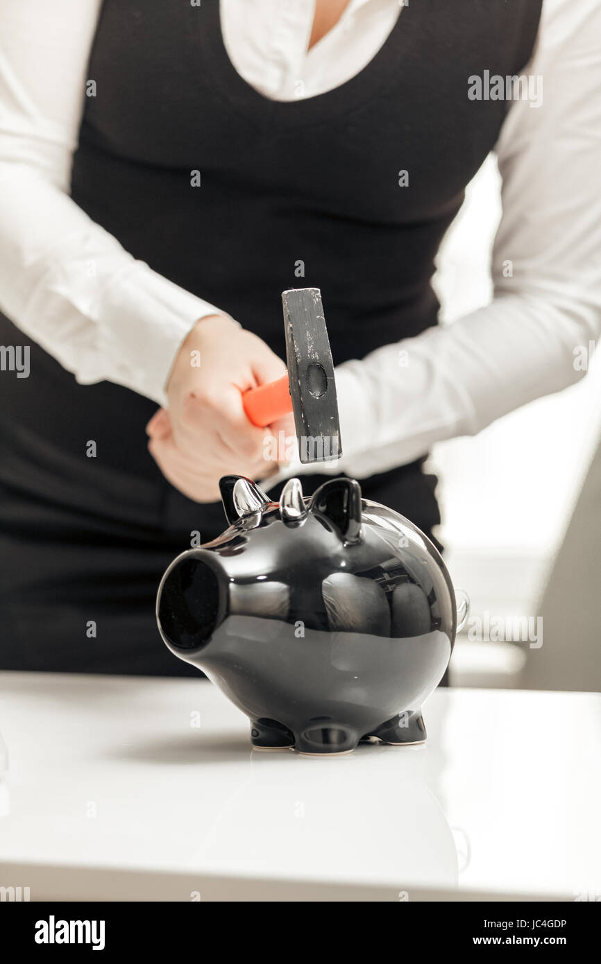 Young businesswoman hitting piggy bank with hammer Stock Photo - Alamy