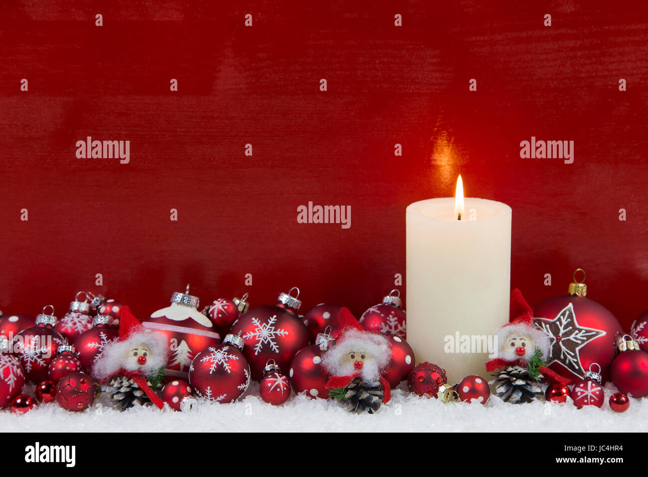 Red wooden christmas background with one burning white candle Stock