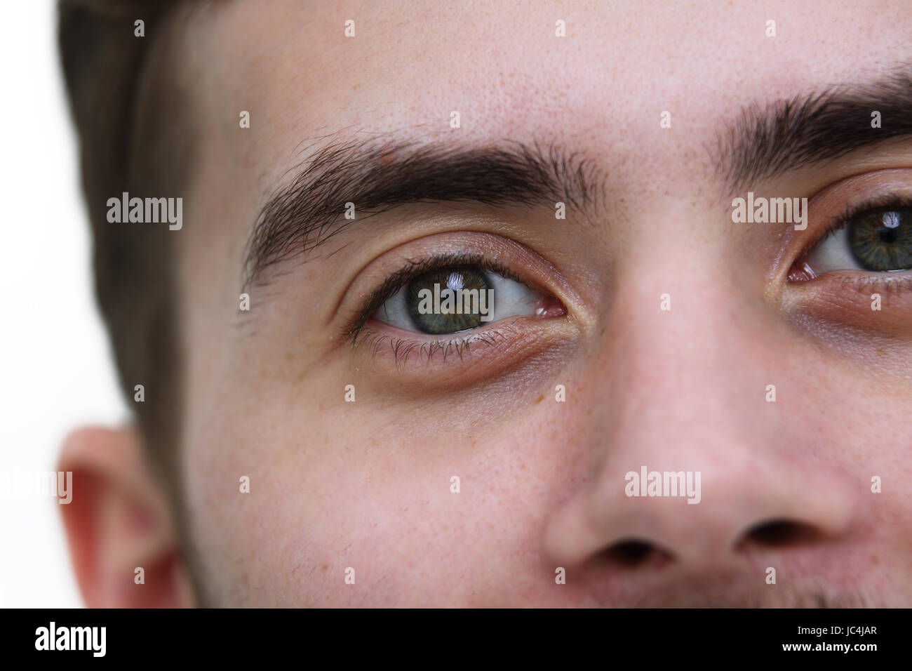 Crop of young man's face looking at camera Stock Photo - Alamy